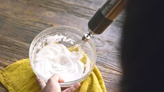 En stavmixer med vispredskap som vispar grädde