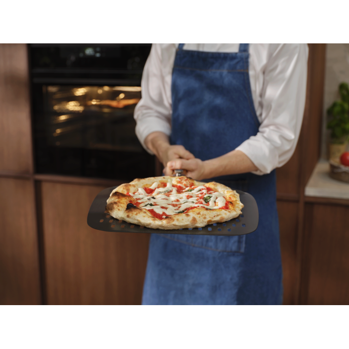 Person holding the pizza expert pizza peel with a Neapolitan pizza