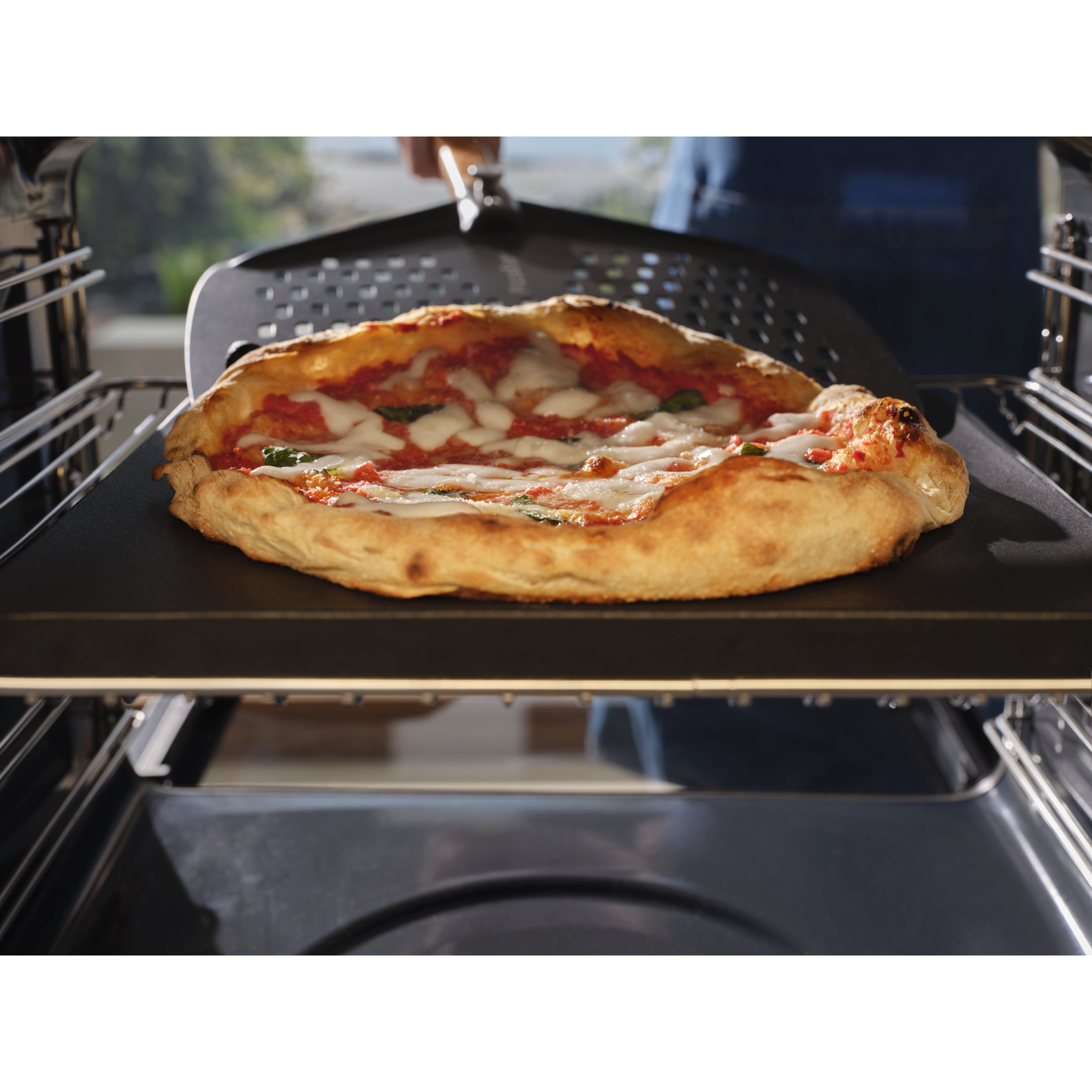 A neapolitan pizza baking inside the pizza expert oven with a pizza peel underneath