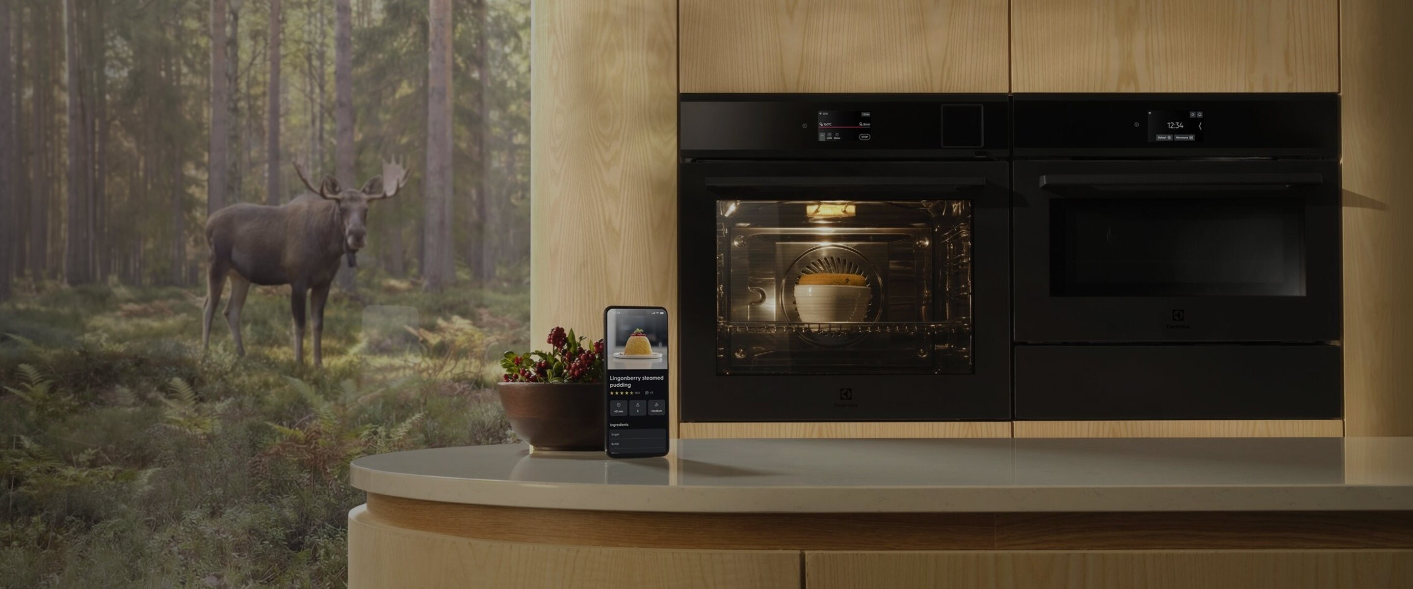 Två svarta Electrolux-ugnar inbyggda i ljust trä, där en smartphone visar AI TasteAssist-appen