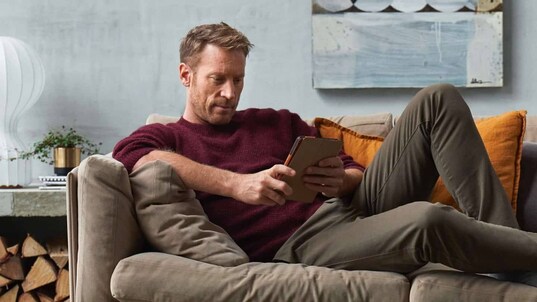 Man som sitter med en smartphone och använder My-Electrolux Care Appen