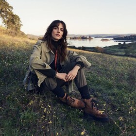 Kvinna som sitter på gräsmatta