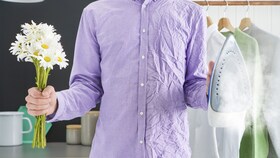 En man klädd i en skjorta, där halva skjortan är skrynklig och den andra halvan slät för att visa fördelarna med SteamCare