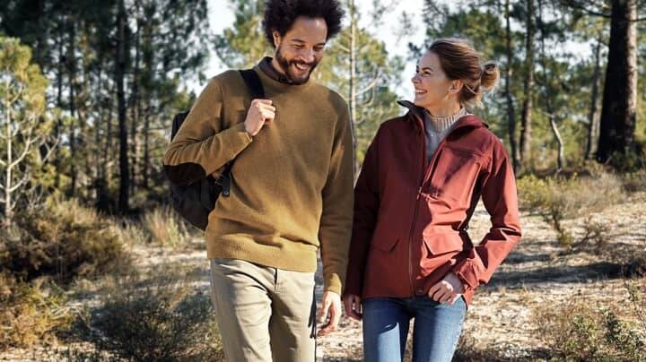 Två personer som går i skog