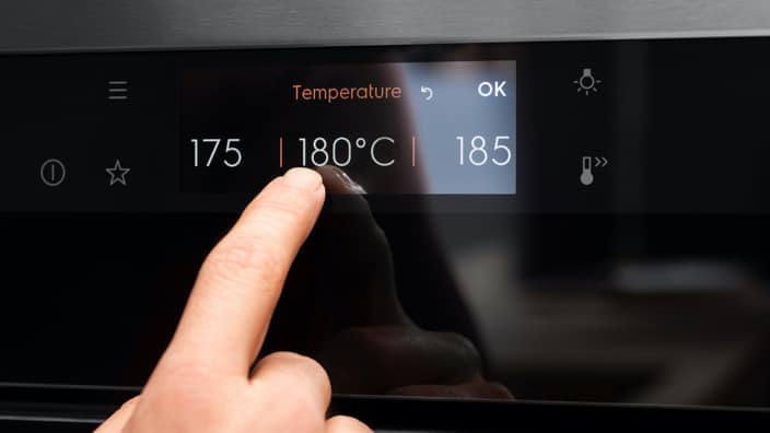 ett finger på touch control på en ugn