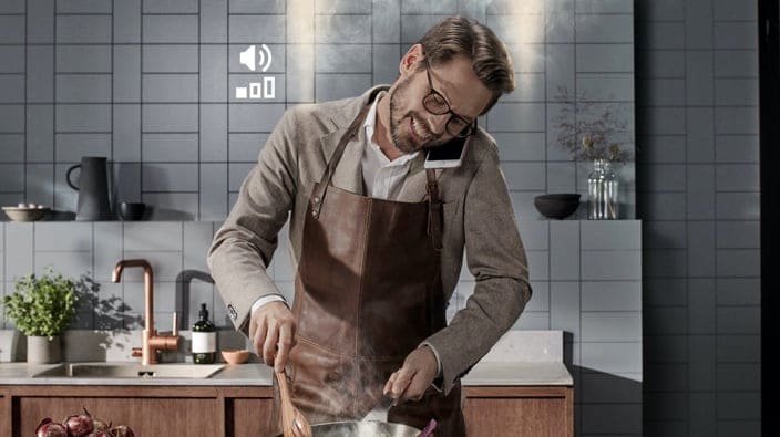 Man som lagar mat och pratar i telefon