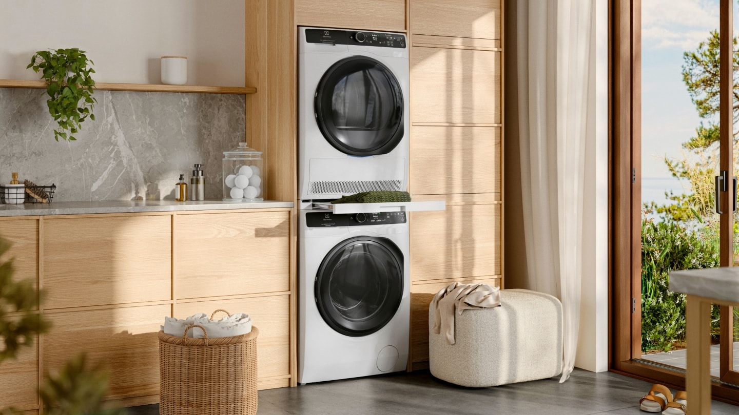 En tvättmaskin och torktumlare från Electrolux, staplade på varandra i en tvättstuga.