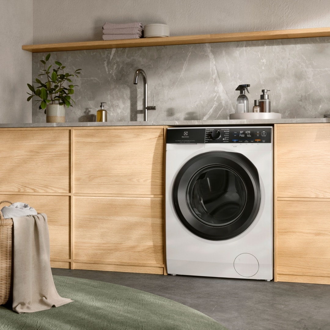 En kombinerad tvättmaskin och torktumlare från Electrolux placerad under en bänk.