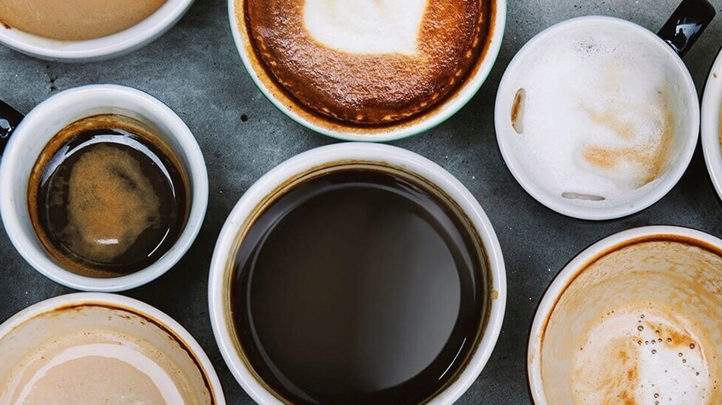Olika koppar med kaffe och espresso