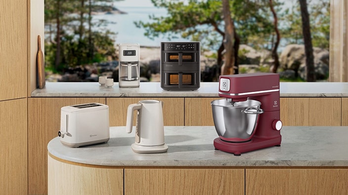 Hushållsapparater inklusive köksassistent, brödrost och airfryer i ett kök
