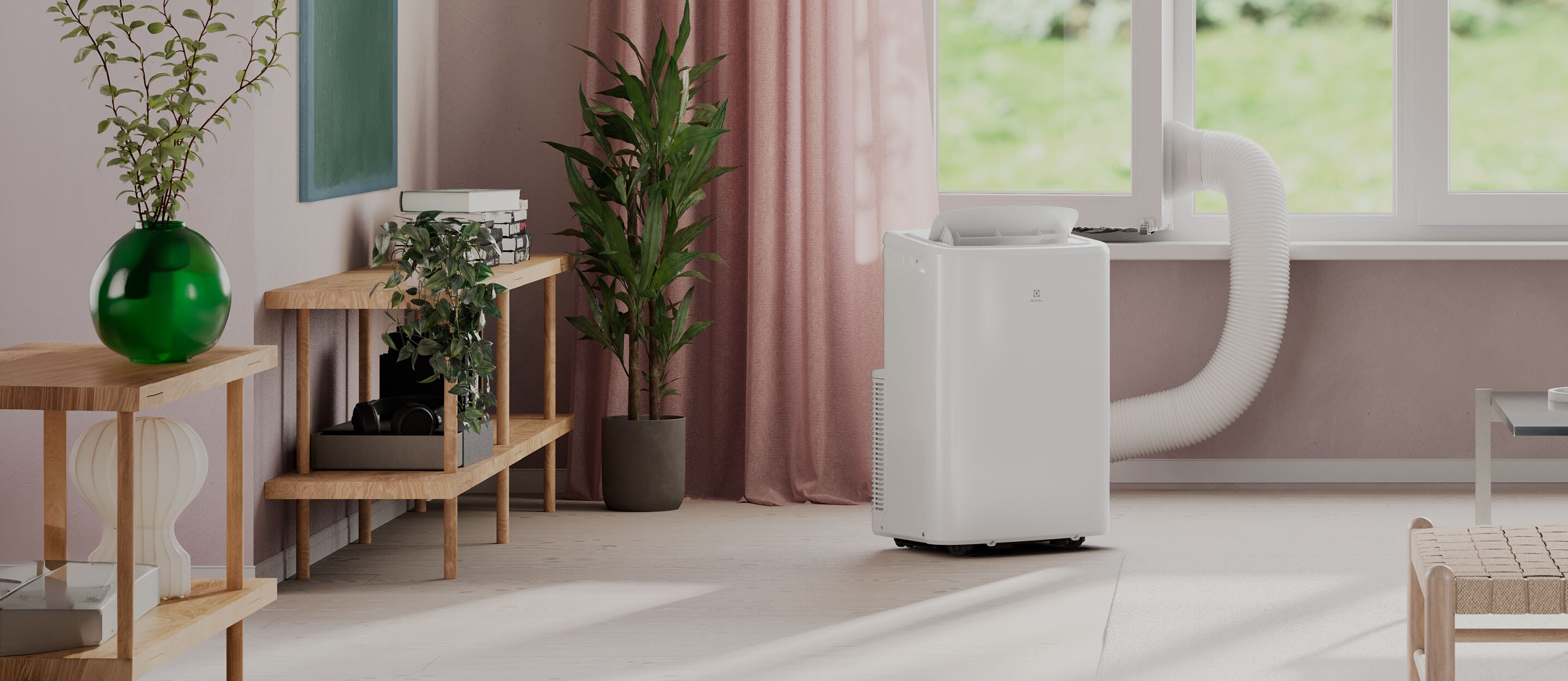 Kompakt, portabel Electrolux AC vid fönster som effektivt kyler rummet och ventilerar bort varm luft via slang.