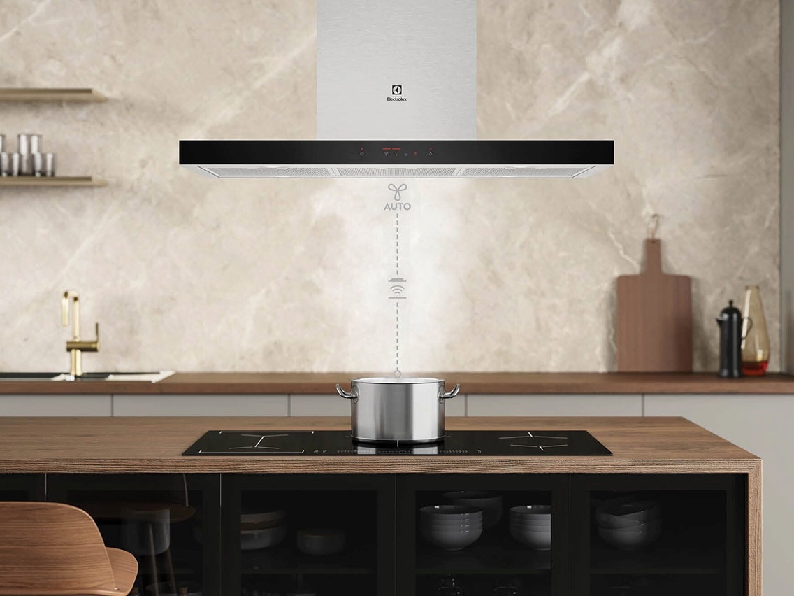 T-formad Electrolux-fläkt över köksö med kokande kastrull; grafik med texten "AUTO" illustrerar Hob2Hood-funktionen