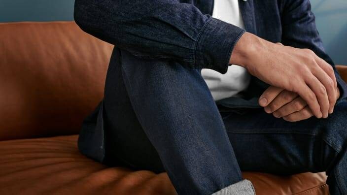 en mann sitter i en soffa